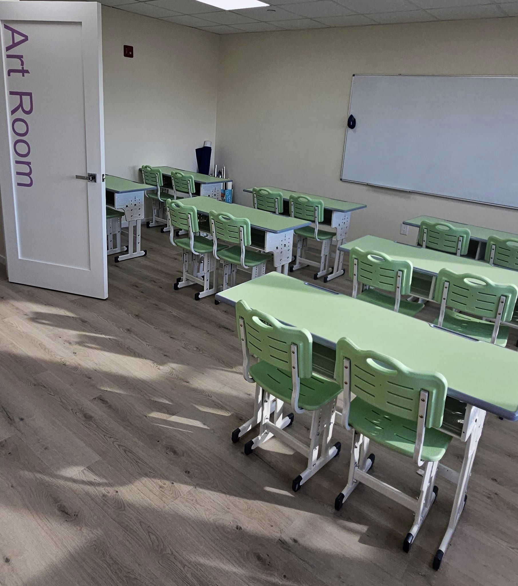 Green desks and chairs in a New York school art classroom